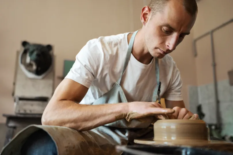 Een persoon die aan pottenbakkerij doet